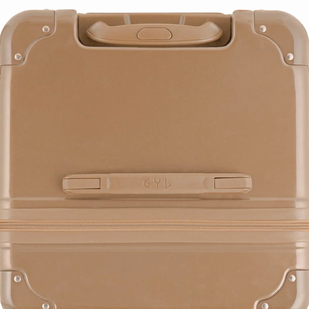 Top view of the GYL trunk suitcase in champagne polycarbonate, with central handle and reinforced corners. #couleur_champagne