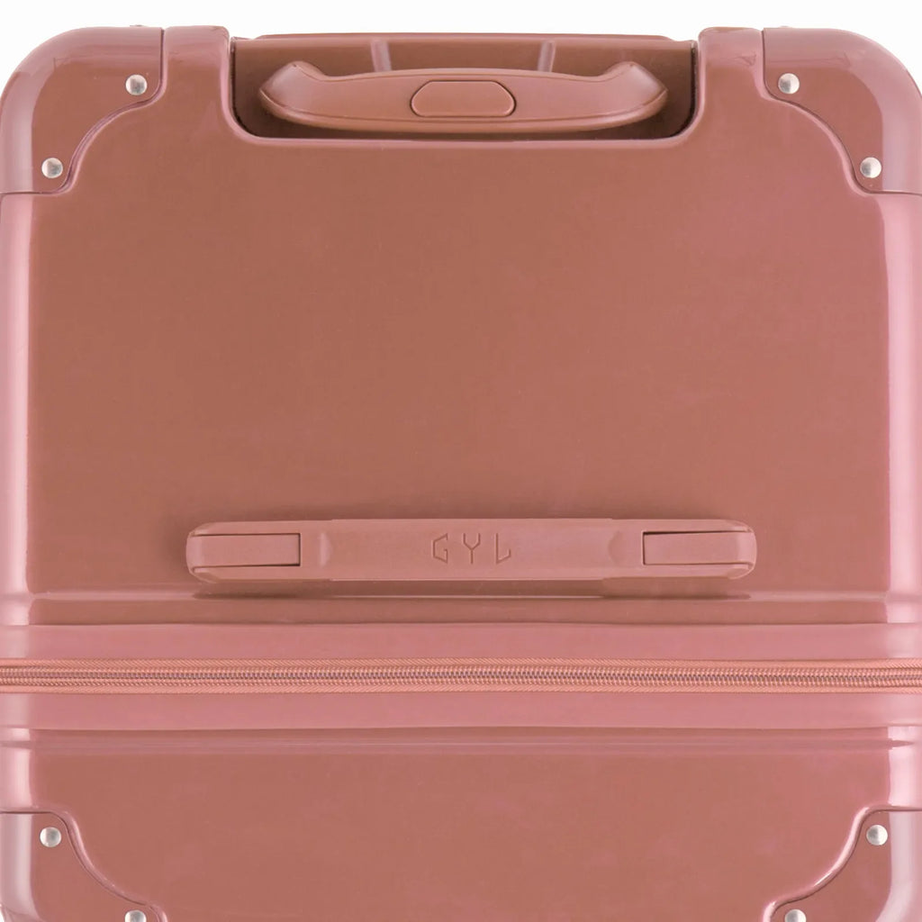 Top view of the GYL trunk suitcase in rose gold polycarbonate, with central handle and reinforced corners. #couleur_rose gold
