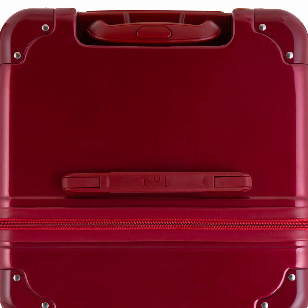 Top view of the GYL trunk suitcase in dark red polycarbonate, with central handle and reinforced corners. #couleur_red foncé