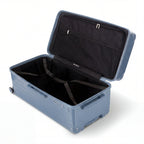 Interior of the open GYL XL dark grey-blue trunk suitcase, with cross straps. #couleur_bleu grisée