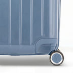 Detail of the wheel and GYL logo on the bottom of the grey-blue trunk suitcase in glossy polycarbonate. #couleur_bleu grisé