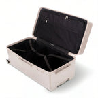 Interior of the GYL Trunk XL nude suitcase open, with crossed straps. #couleur_nude