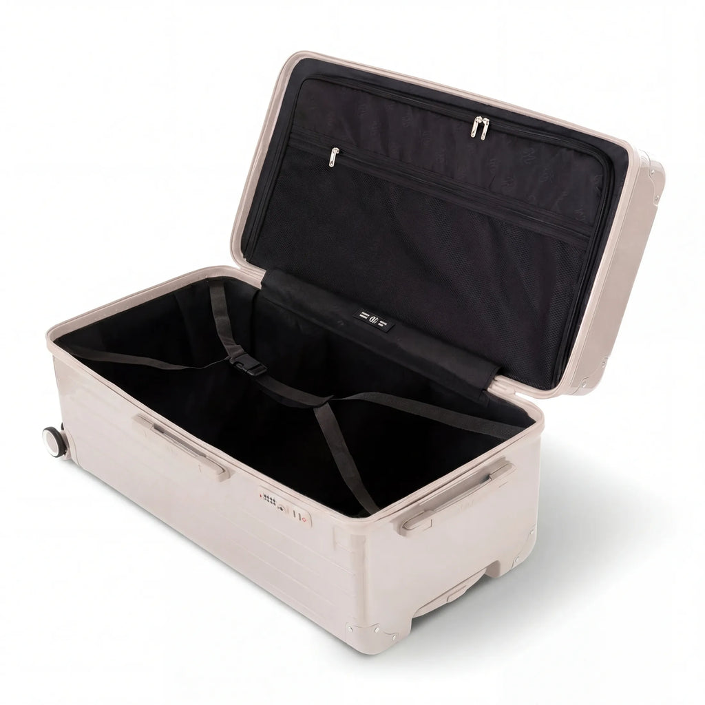 Interior of the open GYL XL nude trunk suitcase, with cross straps. #couleur_nude