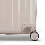 Detail of the wheel and GYL logo on the bottom of the nude trunk suitcase in glossy polycarbonate. #couleur_nude