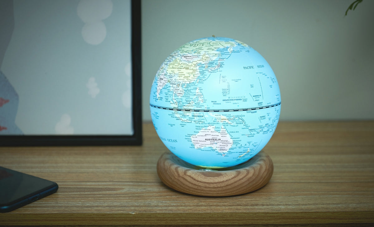 Gingko Design – Lampada Mappamondo Atlas - Blu Chiaro / Base Frassino Bianco - Mini, mappamondo luminoso posato su una base in legno chiaro