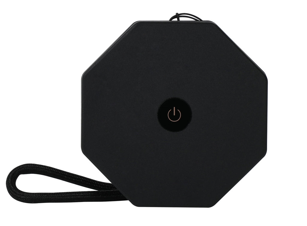 Gingko Design – Luz Twist Hexagon - Negro Pizarra - Mini, vista frontal de un altavoz portátil negro octogonal con un botón central