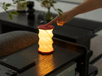Gingko Design – Lumière Twist Hexagon - Rouge Corail - Mini, lampe de table rouge et blanche, allumée, touchée par une main