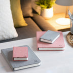 Gingko Design – Lampe Smart Book LED - Lin Rose Poudré - 2 Tailles, deux carnets gris et roses posés sur une table blanche, ambiance cosy