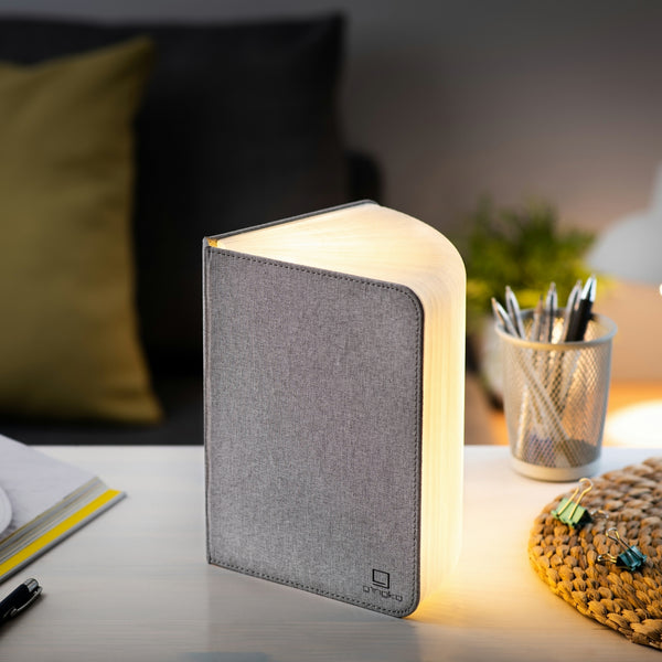 Gingko Design – Lámpara Smart Book LED - Lino Gris Urbano - 2 Tamaños, lámpara libro abierta en un escritorio, luz cálida, ambiente acogedor