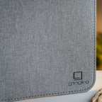 Gingko Design – Lámpara Smart Book LED - Lino Gris Urbano - 2 Tamaños, primer plano de tela gris con logotipo negro en la esquina inferior derecha