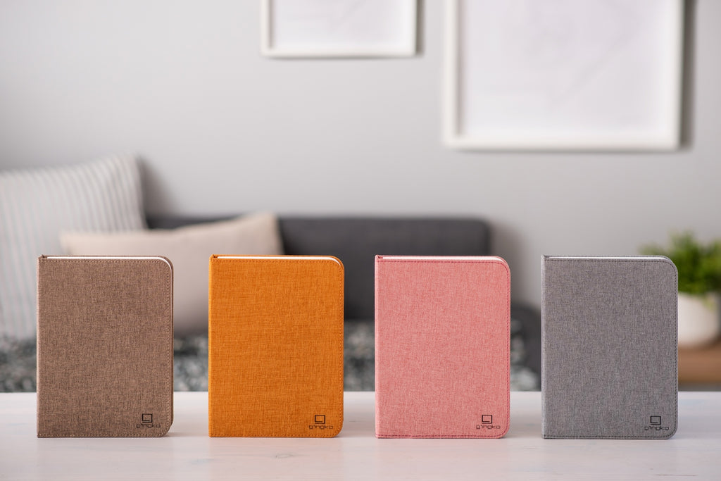 Gingko Design – Smart Book LED-lampe - Harmony Orange Hør - 2 Størrelser, fire notesbøger i forskellige farver på et hvidt bord