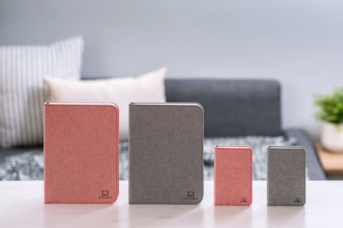 Gingko Design – Lampe Smart Book LED - Lin Rose Poudré - 2 Tailles, quatre carnets de notes de différentes tailles et couleurs sur une table