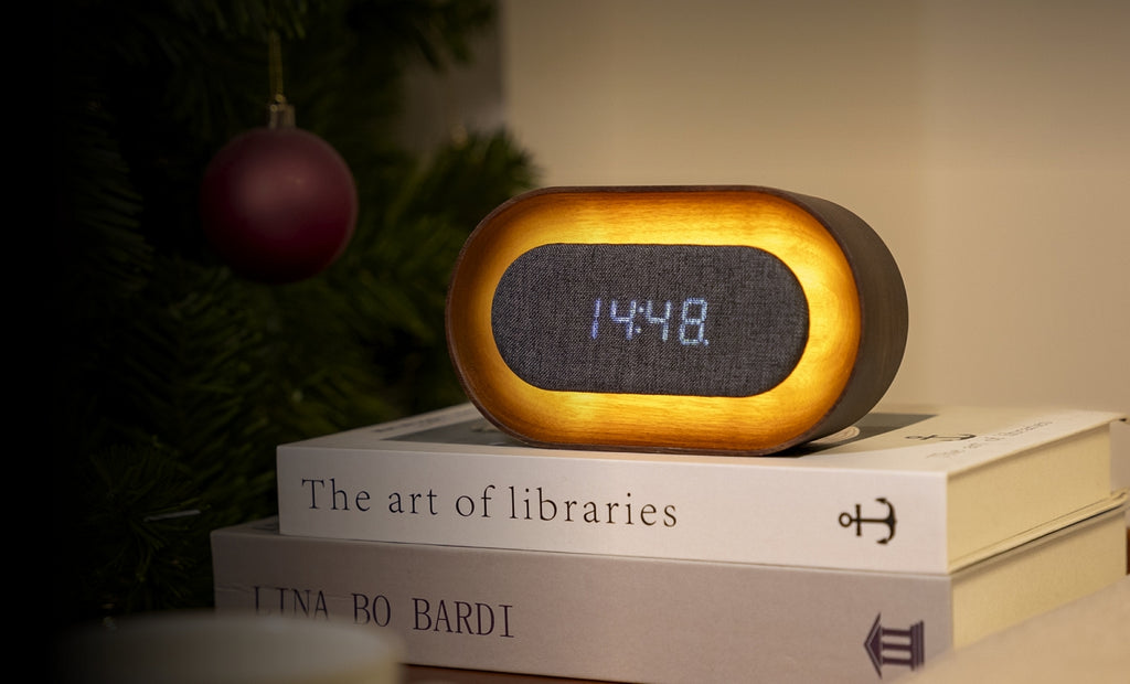Gingko Design – Lumos Uhr - Oval Walnuss, ovaler digitaler Wecker aus hellem Holz und grauem Stoff auf Büchern