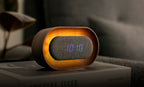 Gingko Design – Lumos Uhr - Oval Walnuss, digitaler Wecker aus Holz und Stoff mit Zeitanzeige auf einem Buch