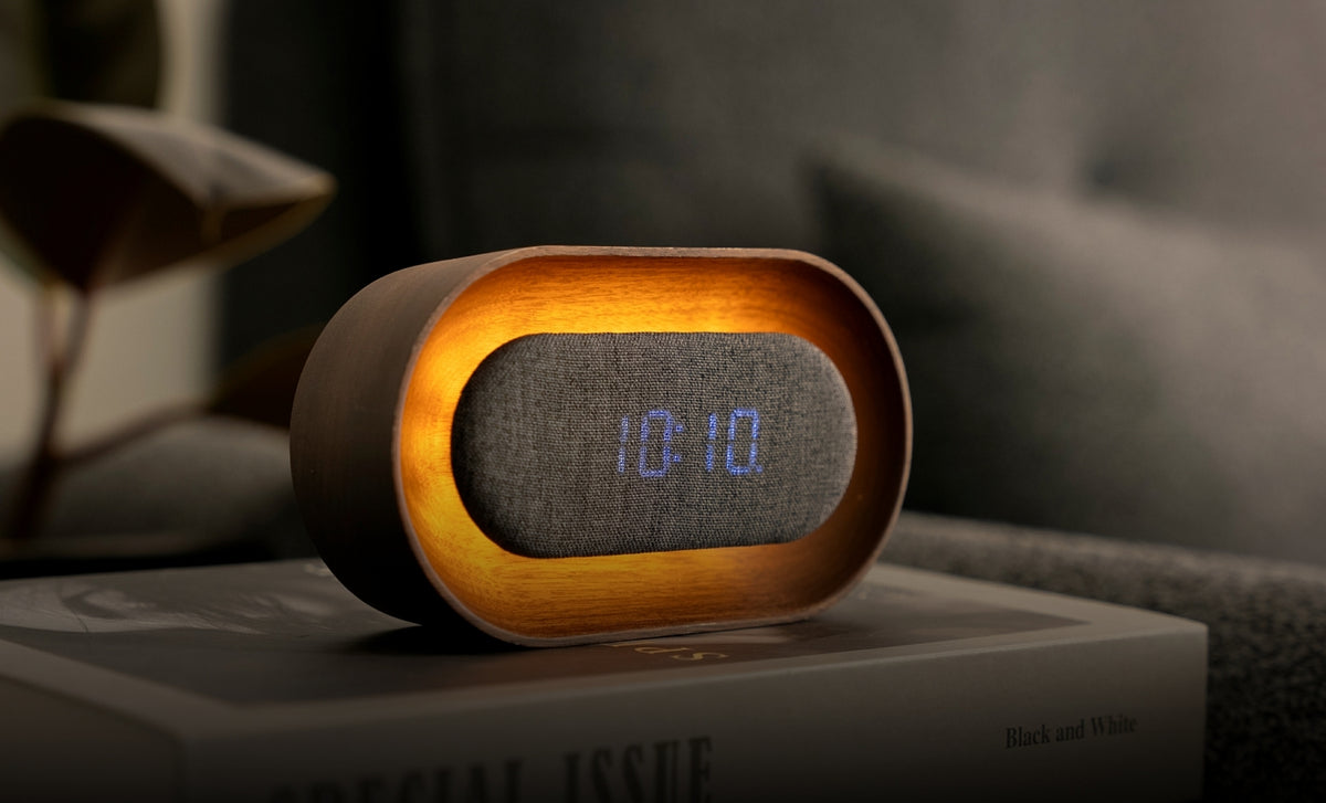 Gingko Design – Lumos Uhr - Oval Walnuss, digitaler Wecker aus Holz und Stoff mit Zeitanzeige auf einem Buch