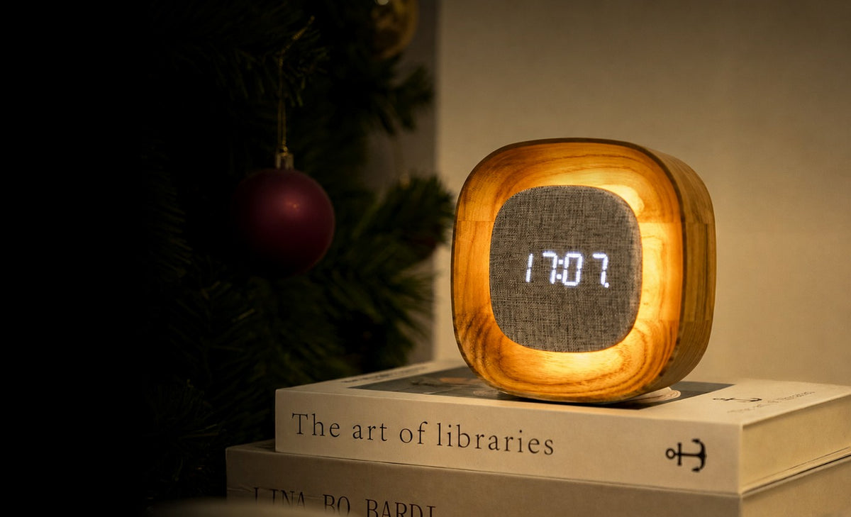 Gingko Design – Reloj Lumos - Cuadrado Fresno Blanco, despertador de madera clara y tela gris, colocado sobre unos libros