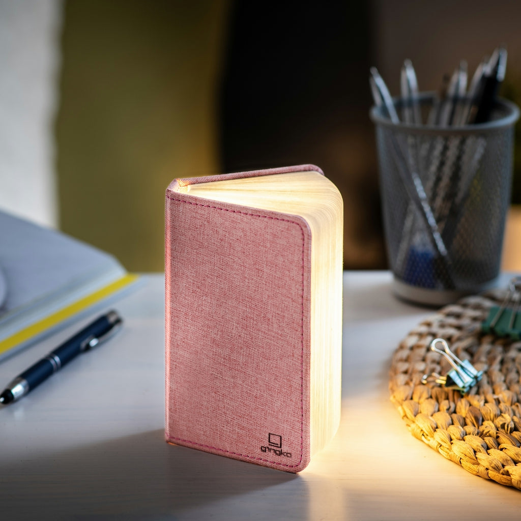 Gingko Design – Lampe Smart Book LED - Lin Rose Poudré - 2 Tailles, lampe de bureau en forme de livre rose, allumée sur un bureau