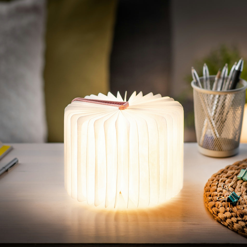 Gingko Design – Lampe Smart Book LED - Lin Rose Poudré - 2 Tailles, lampe livre lumineuse posée sur un bureau en bois clair