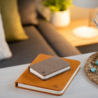 Gingko Design – Lampada Smart Book LED - Lino Marrone Caffè - Mini, due taccuini posati su un tavolino in un salotto