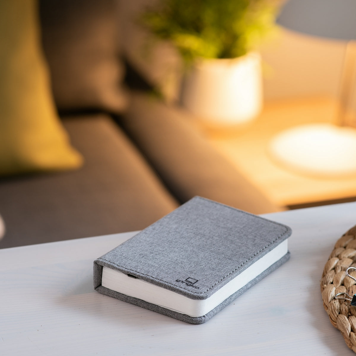Gingko Design – Lámpara Smart Book LED - Lino Gris Urbano - 2 Tamaños, libro gris colocado sobre una mesa de centro en un salón