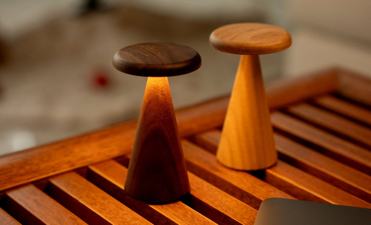 Gingko Design – Lámpara de mesa Sylva - Fresno blanco - 2 tamaños, dos lámparas de mesa de madera, una de ellas encendida, sobre una mesa de madera