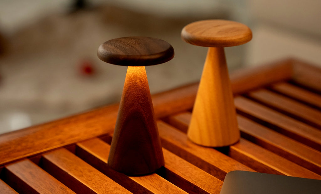 Gingko Design – Lámpara de mesa Sylva - Nogal - 2 tamaños, dos lámparas de mesa de madera, una de ellas encendida, sobre una mesa de madera