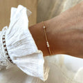 Instants Plaisirs – Bracelet "Antonin" Perles Plaqué Or, bracelet fin doré avec perles blanches porté sur un poignet féminin