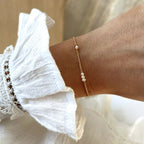 Instants Plaisirs – Bracelet "Antonin" Perles Plaqué Or, bracelet fin doré avec perles blanches porté sur un poignet féminin