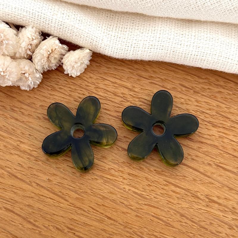 Instants Plaisirs – Fleurs "Maria" Acétate, deux perles en forme de fleur vert foncé sur une table en bois