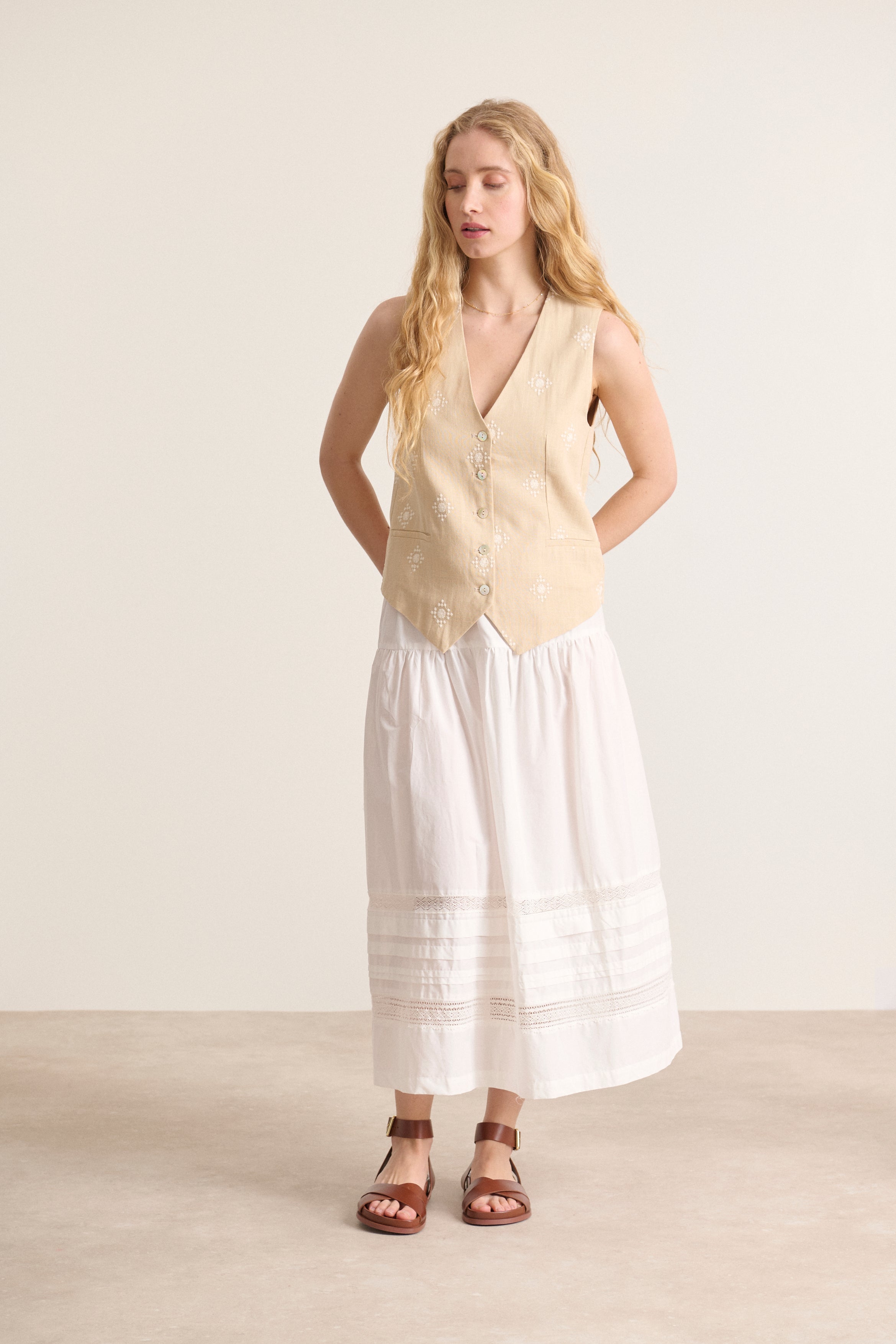Jupe blanche en popeline doublée, taille élastique, détails de découpes et plis, agrémentée de dentelle élégante