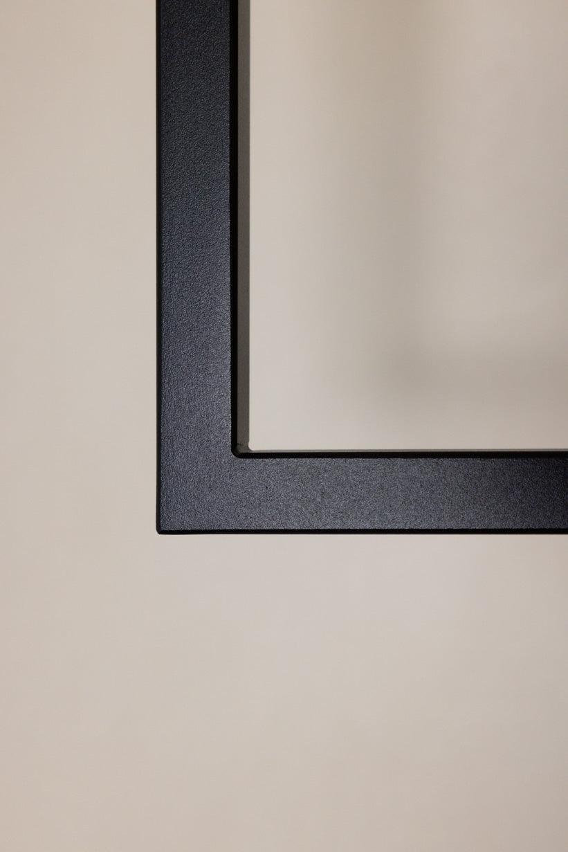 Detalles del schlichten schwarzen Rahmens an einer hellen Wand.