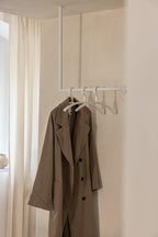Ropa RUBI con elegante abrigo beige y dos botones blancos en el tobillo.
