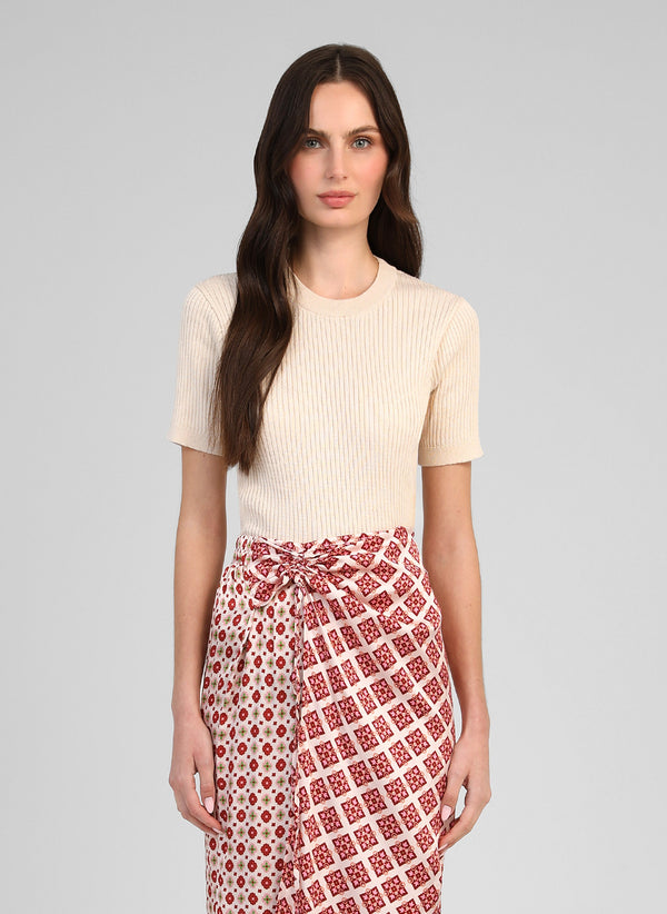 An'ge – Pull Lesienna Ecru, modelo con un top acanalado beis y una falda larga estampada