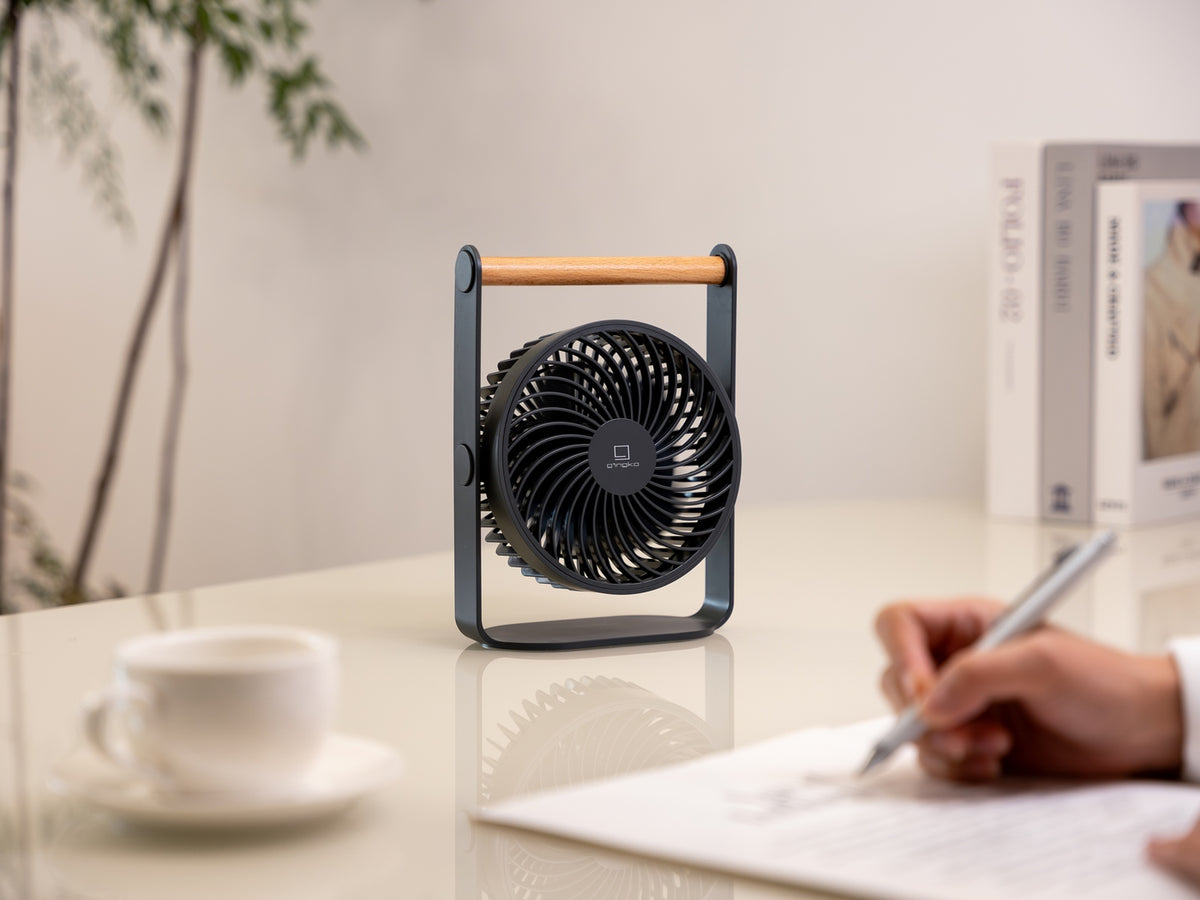 Gingko Design – Ventilatore Portatile Lyra - Grigio Siderale, ventilatore da tavolo nero e legno, appoggiato su una scrivania