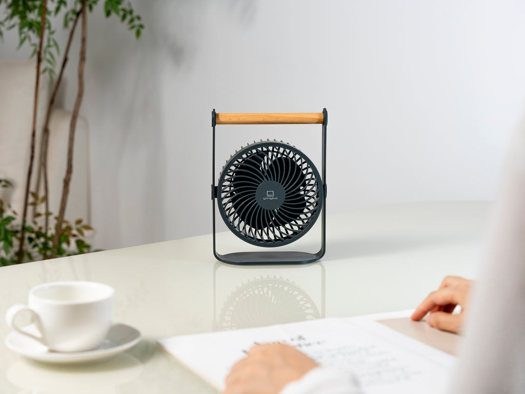 Gingko Design – Ventilatore Portatile Lyra - Grigio Siderale, ventilatore da tavolo nero con supporto in legno, appoggiato su una scrivania bianca