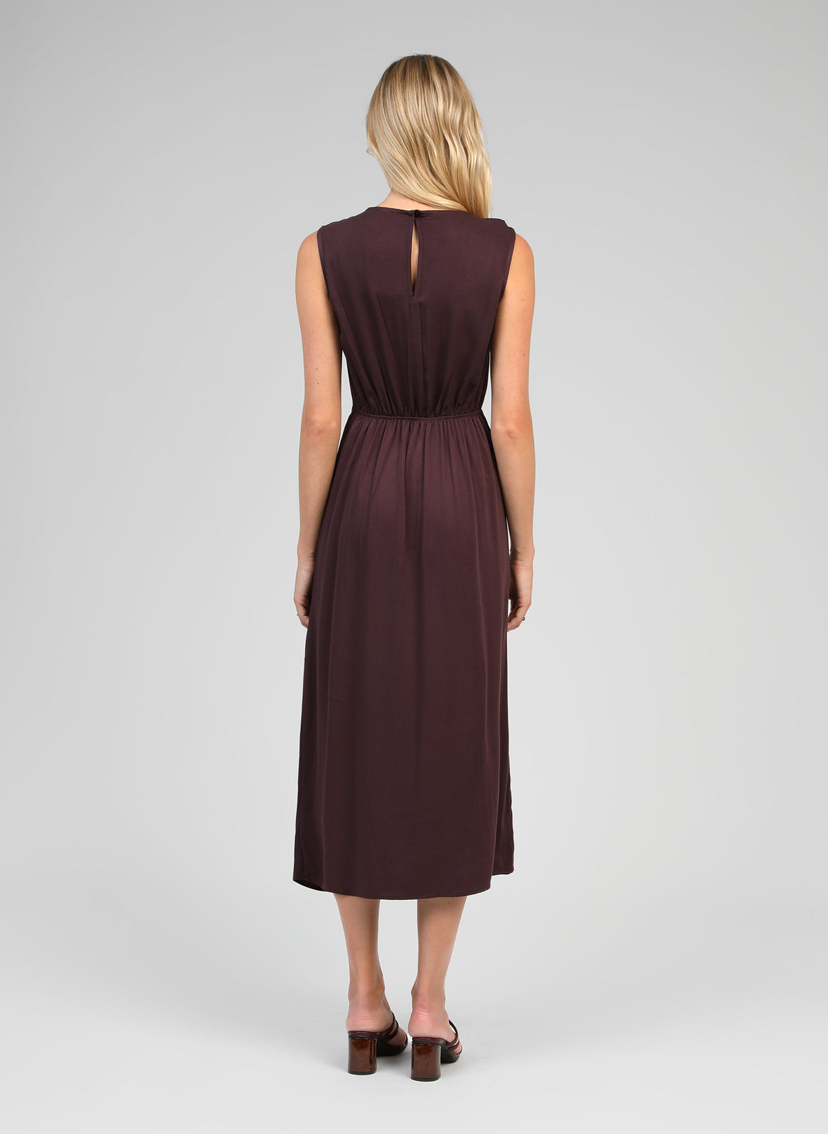 An'ge – Robe Midi Mystral Wine, modella di schiena che indossa un abito lungo marrone scuro