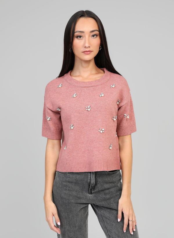 An'ge – Sweter Nelida Rose, modelka w różowym swetrze z krótkim rękawem i perełkami