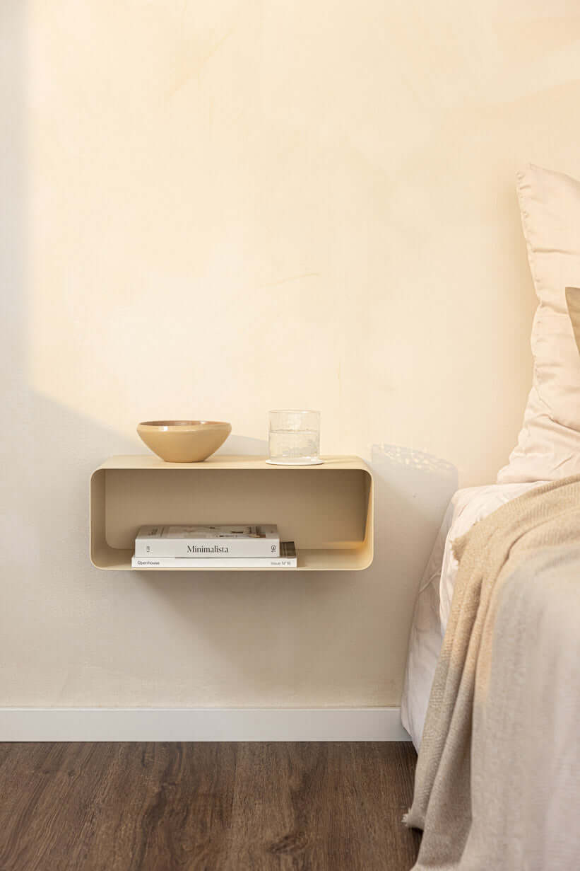 Hängender Nachttisch NELIO in minimalist Formensprache über einem Bett mit Deko-Objekten.