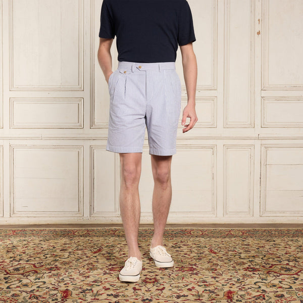 Hast – Dubbelveckade bermudashorts i blårandig seersucker, modell i ljusblårandiga shorts och marinblå t-shirt