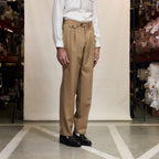 Hast – Camel Double-Pleated Virgin Wool Trousers, beige trousers worn by a man, side view, on a light background