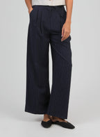 An'ge – Pantaloni Patila Marine, pantaloni a gamba larga blu navy a righe sottili bianche indossati da una modella