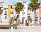Lé Papiers De Ninon – Tapeta Panoramiczna Lisboa - Multicolore, rattanowa sofa z białymi poduszkami w kolorowej śródziemnomorskiej aranżacji