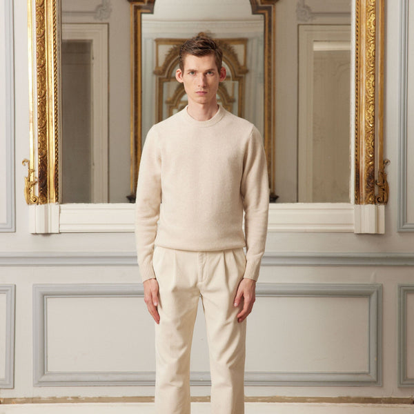 Hast – Tröja i melerad beige merinoull, manlig modell i ljusbeige tröja och byxor