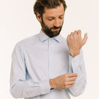 Hast – Two-Ply Twill Shirt in Sky Blue, bearded man adjusting his light blue shirt, front view