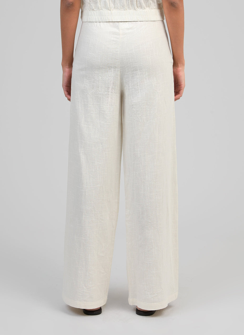 An'ge – Rossalie Trousers Ecru, off-white wide-leg linen trousers worn from behind by a model