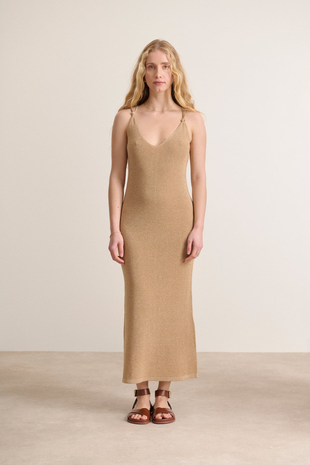 Vestido ceñido con delicados lazos en los tirantes en un vestido de color dorado brillante que realza la silueta.