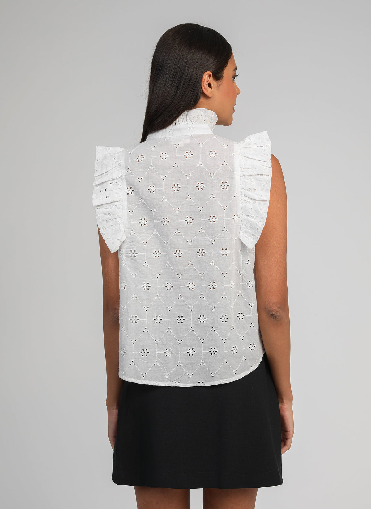 An'ge – Camicia Seliza Ecru, modella di spalle con top bianco ricamato e gonna nera