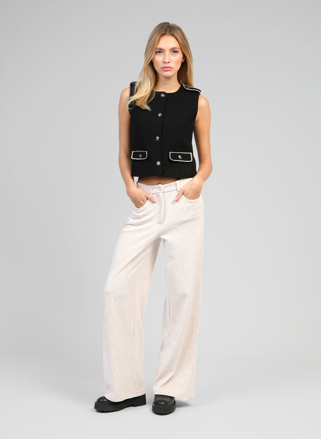 An'ge – Chaqueta Soleda Negro, modelo mujer con chaleco negro y pantalón beige