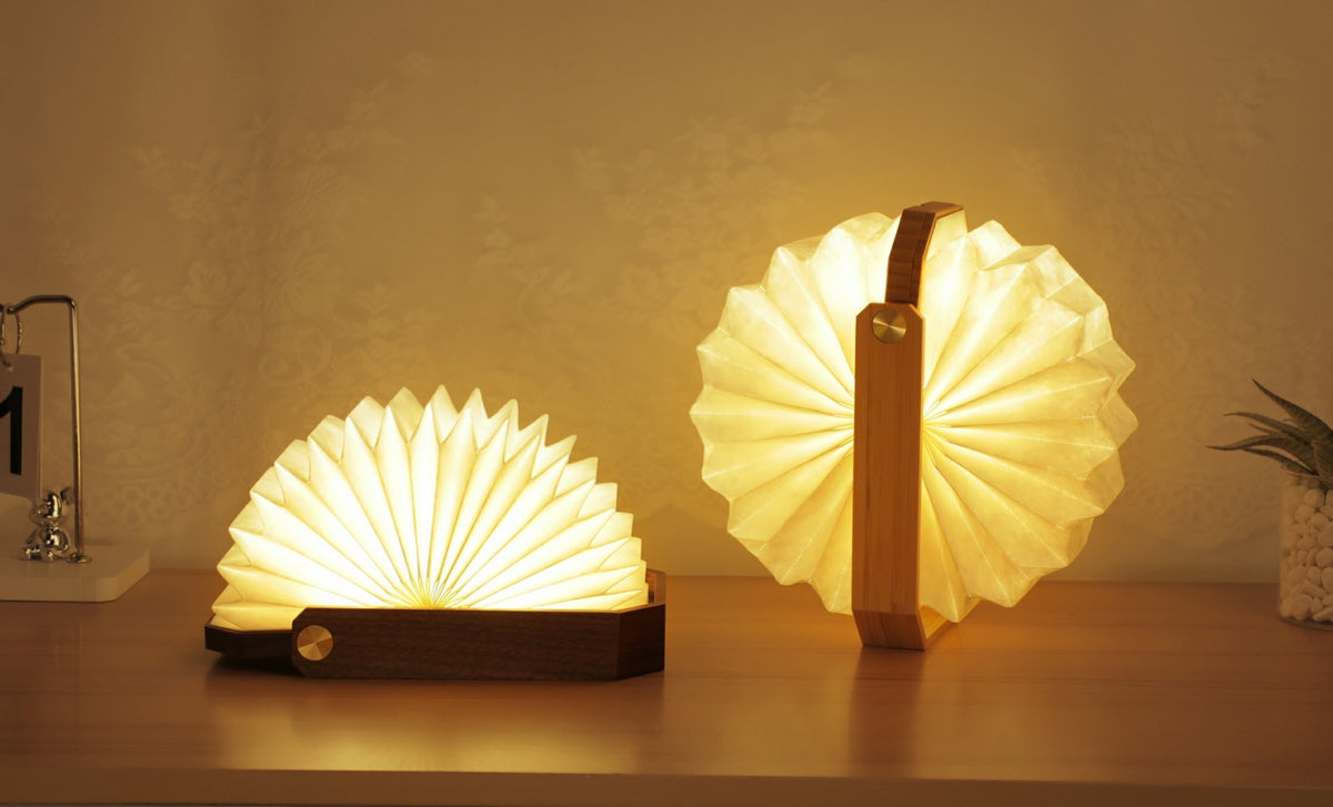 Gingko Design – Lámpara Smart Origami - Bambú Natural, dos lámparas plegables de madera y papel encendidas sobre una mesa