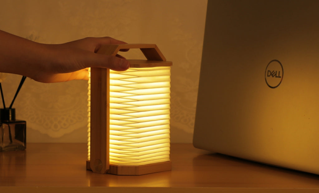 Gingko Design – Lámpara Smart Origami - Bambú Natural, lámpara plegable de madera y papel, colocada sobre una mesa